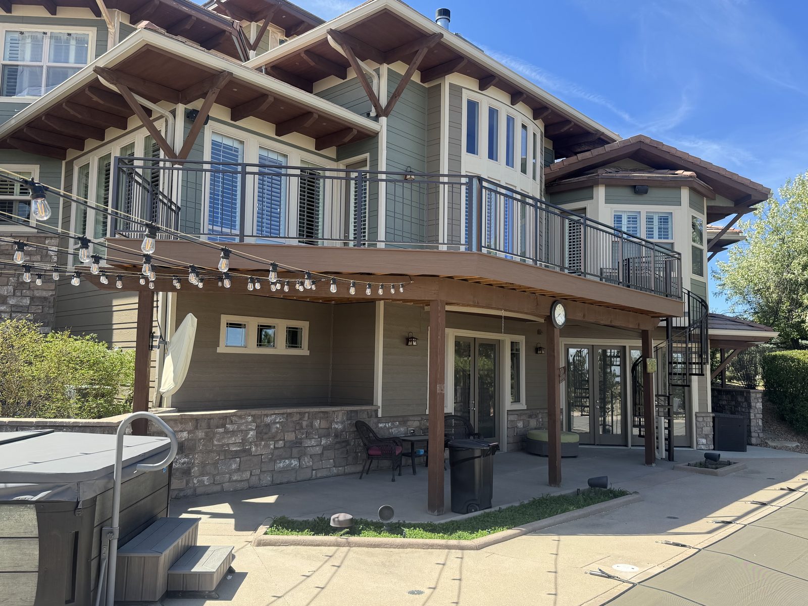 An elevated cable-rail deck with a timber pergola and string lights on a craftsman home in south Denver, built by Haka Decks.